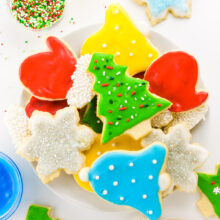 A number of holiday themed Vegan Sugar Cookies are on a white counter top.