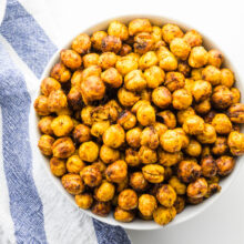 Looking down on a bowl of chickpeas next to a kitchen towel.