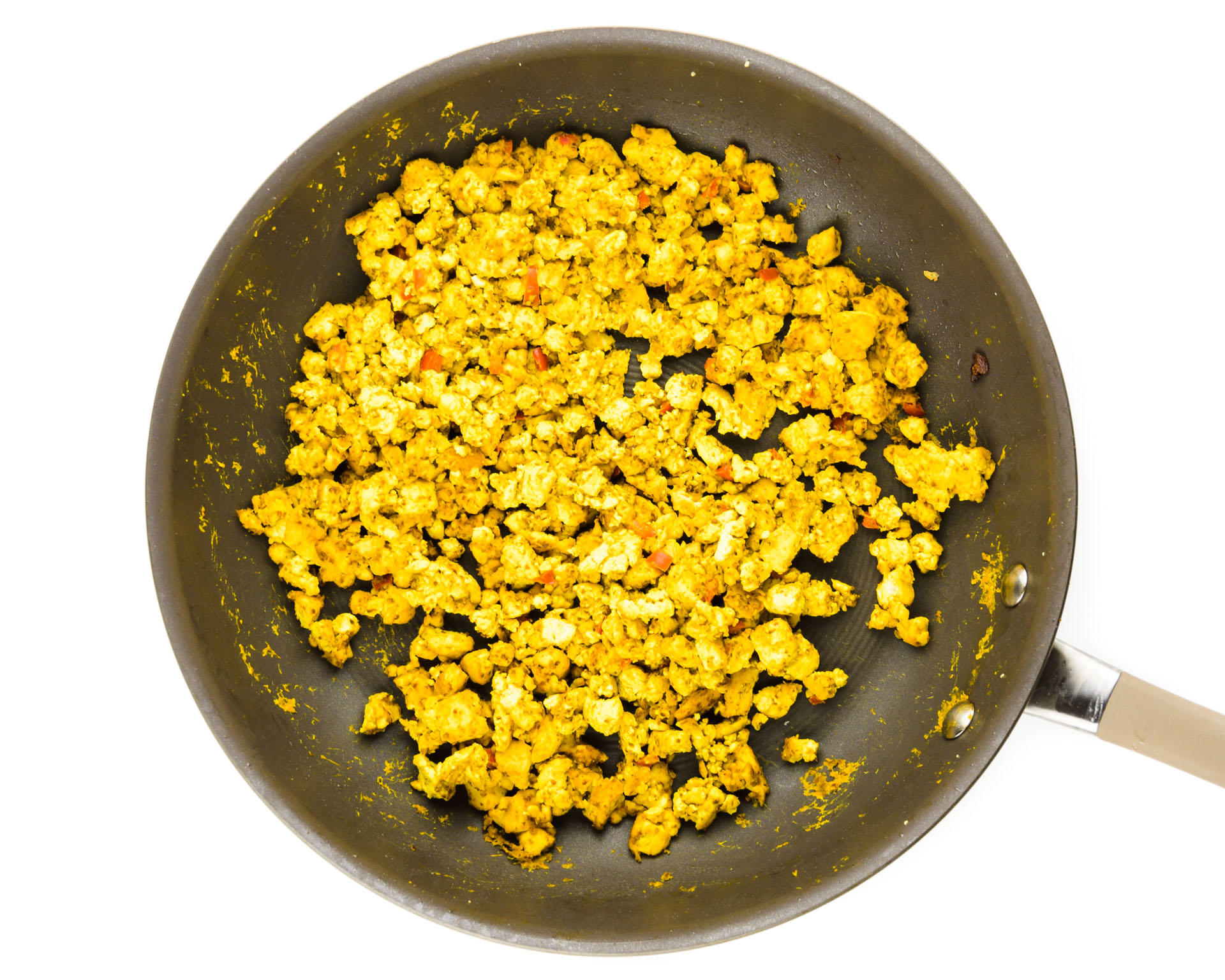 A skillet holds scrambled tofu.