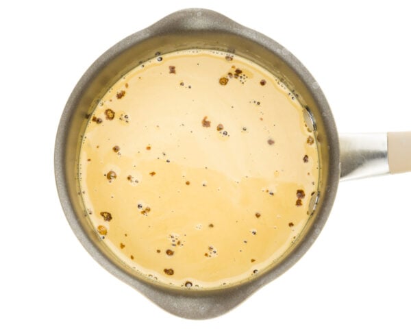 Vegan cream and sugar has been added to a saucepan. It is a light golden color.