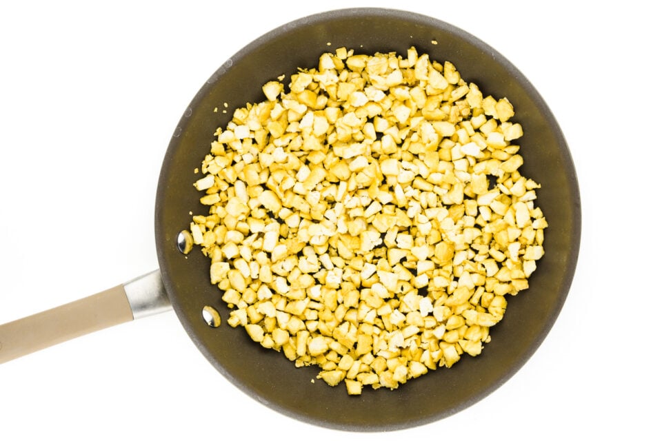 A skillet is full of tofu broken down into bits.