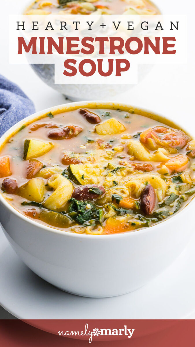 Vegan minestrone soup in a white bowl, featuring colorful vegetables and herbs in a hearty broth.