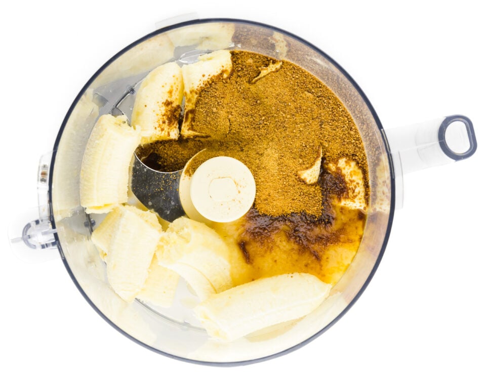 Bananas and other ingredients are in a food processor.