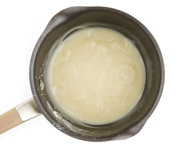 Looking down on plant-based milk and other ingredients in a saucepan.