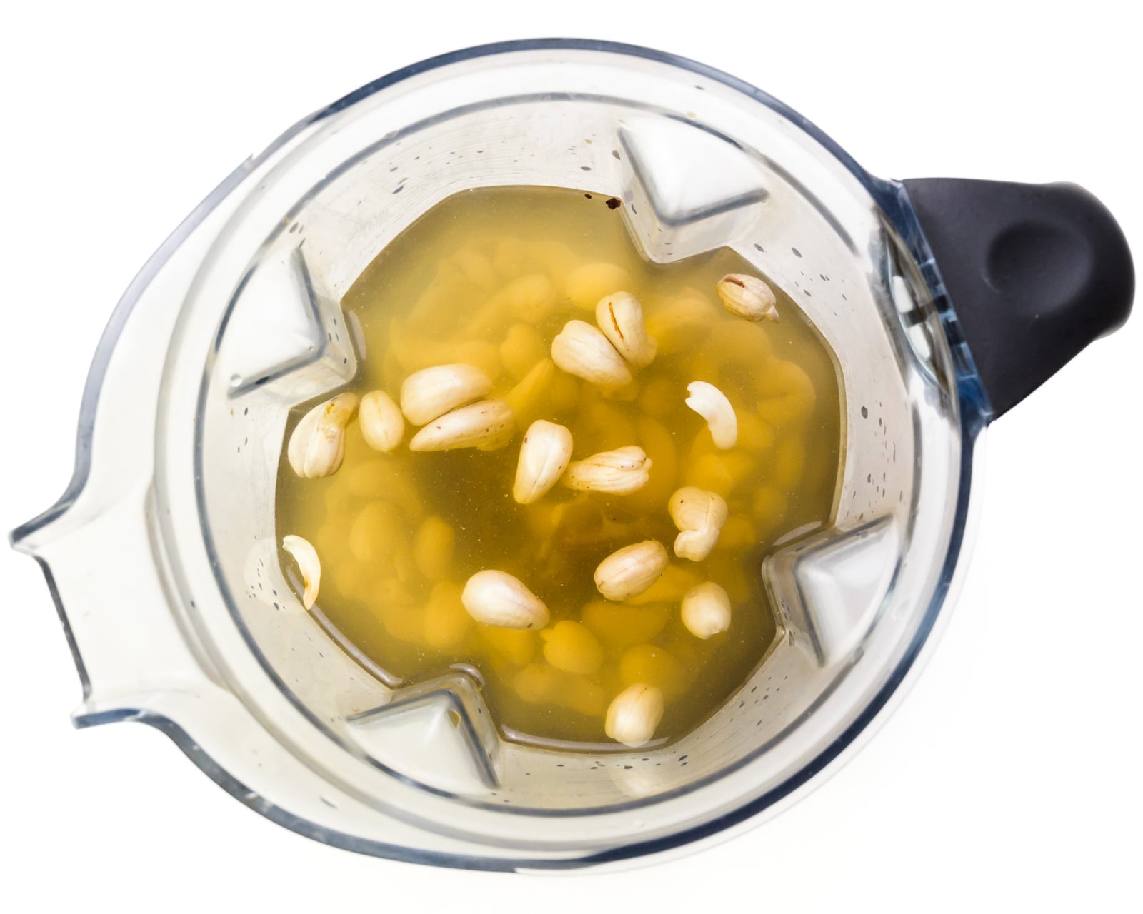 Ingredients are in a blender jar, including cashews, vanilla, and water.