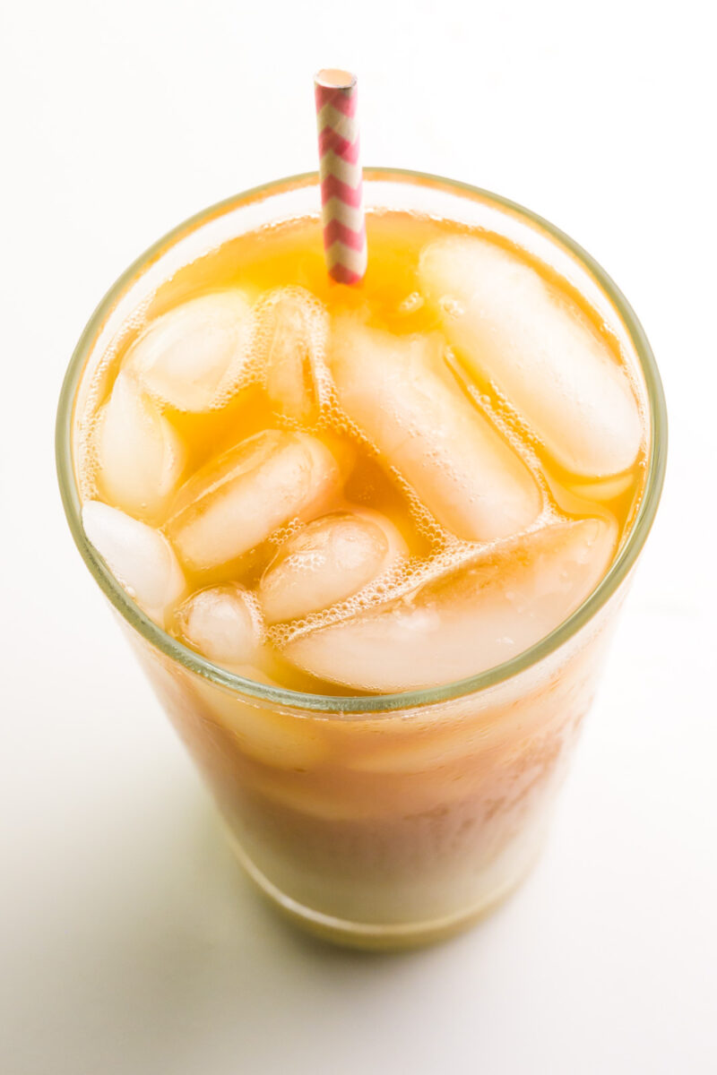 Iced Vanilla Chai Looking down on ice cubes and a straw in a glass of iced tea.