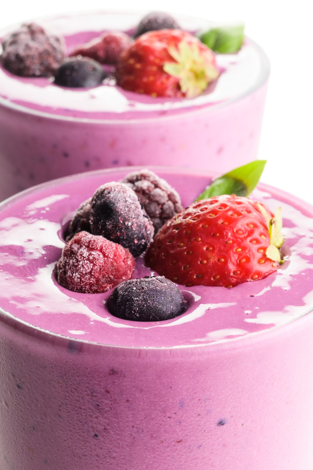 A close-up shot showing the tops of two glasses full of berry smoothies, with berries right on top!