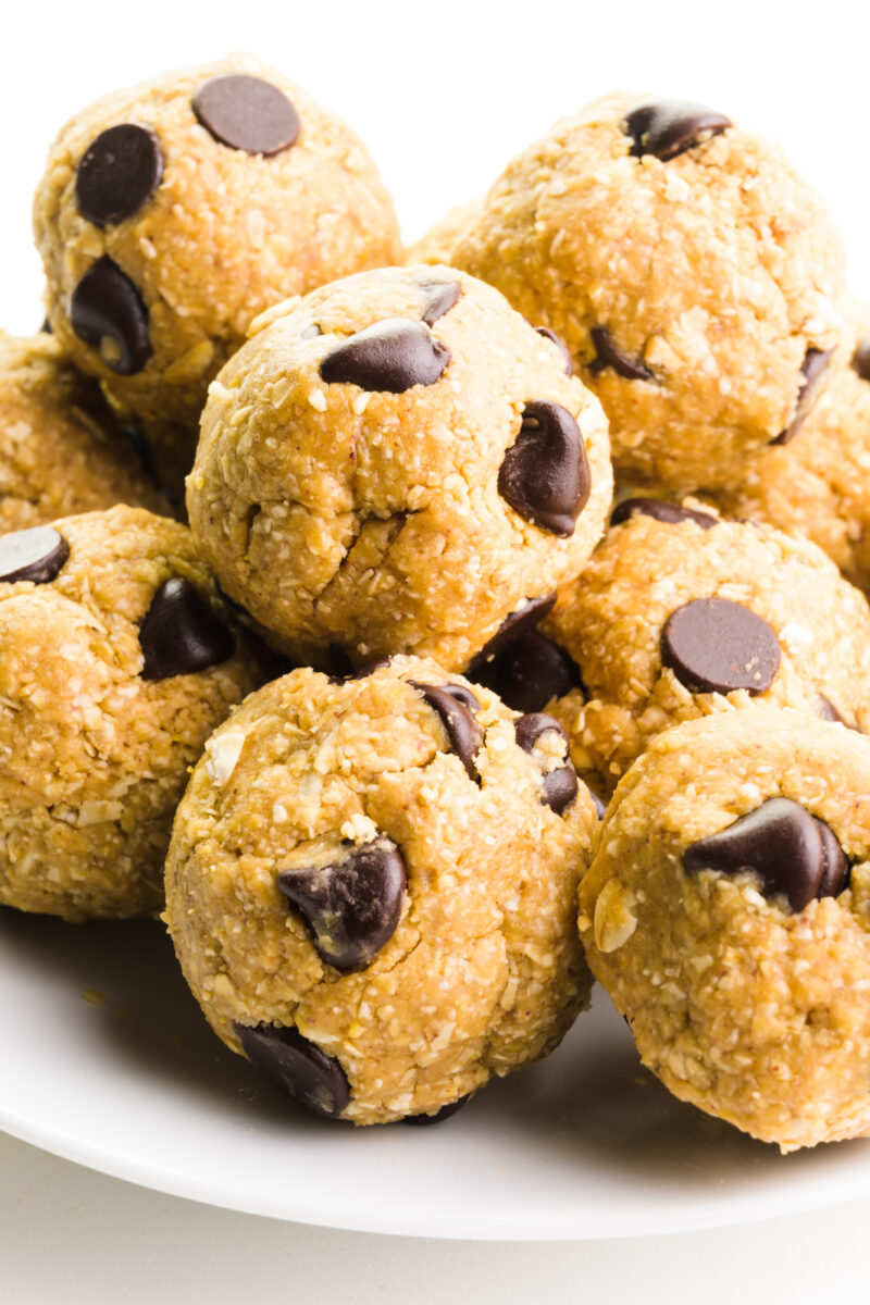 Several chocolate chip cookie dough balls are on a plate.