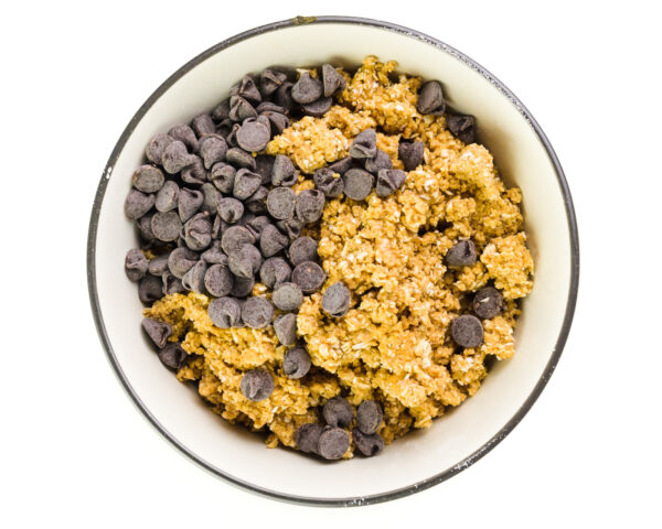 Looking down on a bowl full of cookie dough with chocolate chips recently added.