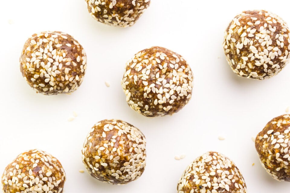 Looking down on several date balls on a white table.
