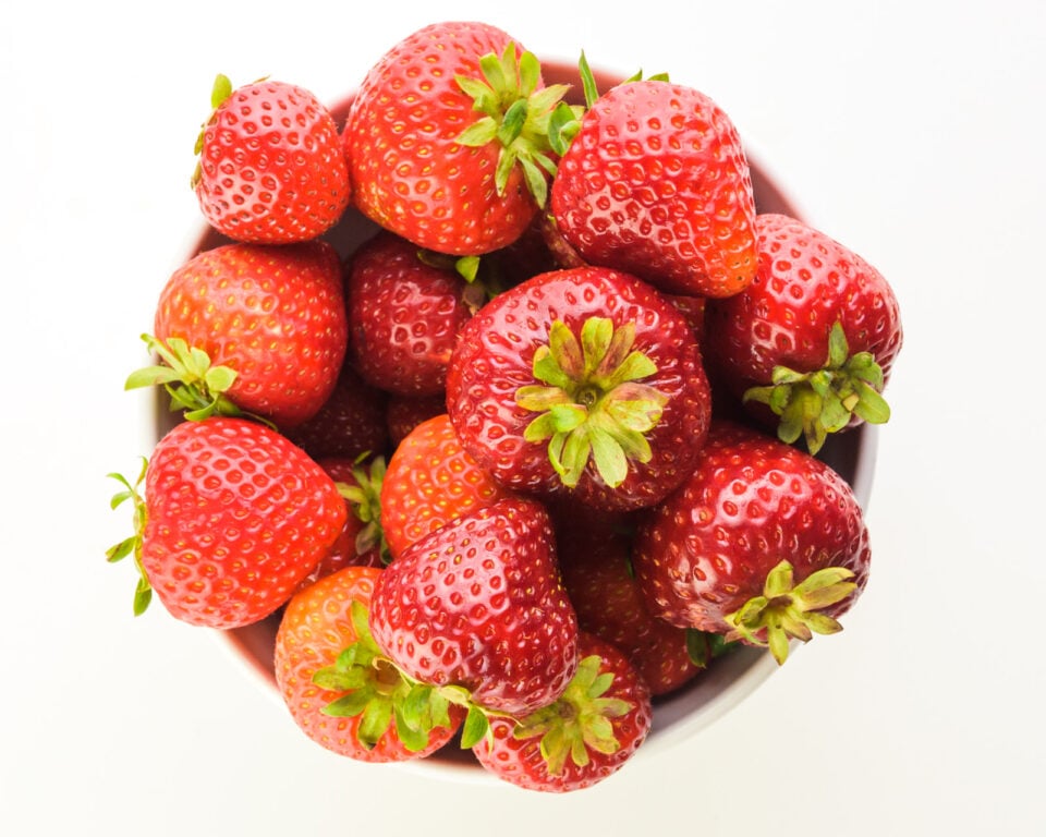 Looking down on a bowl of fresh strawberries in a bowl.