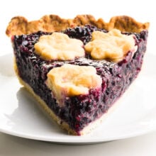 A slice of elderberry pie on a plate.