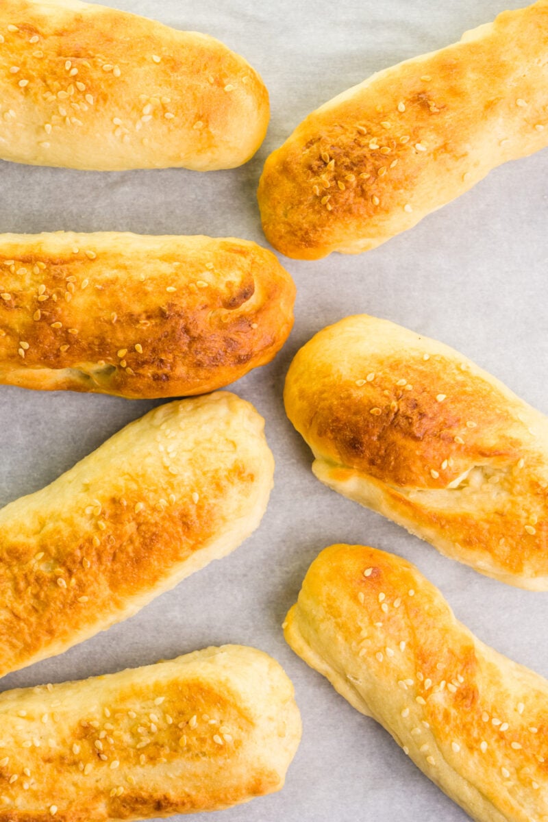 Looking down on several baked buns on a baking sheet.