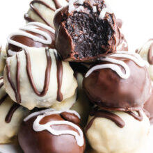 A plate holds several chocolate candies, one with a bite taken out.