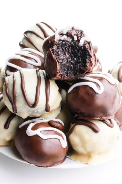 A plate holds several chocolate candies, one with a bite taken out.