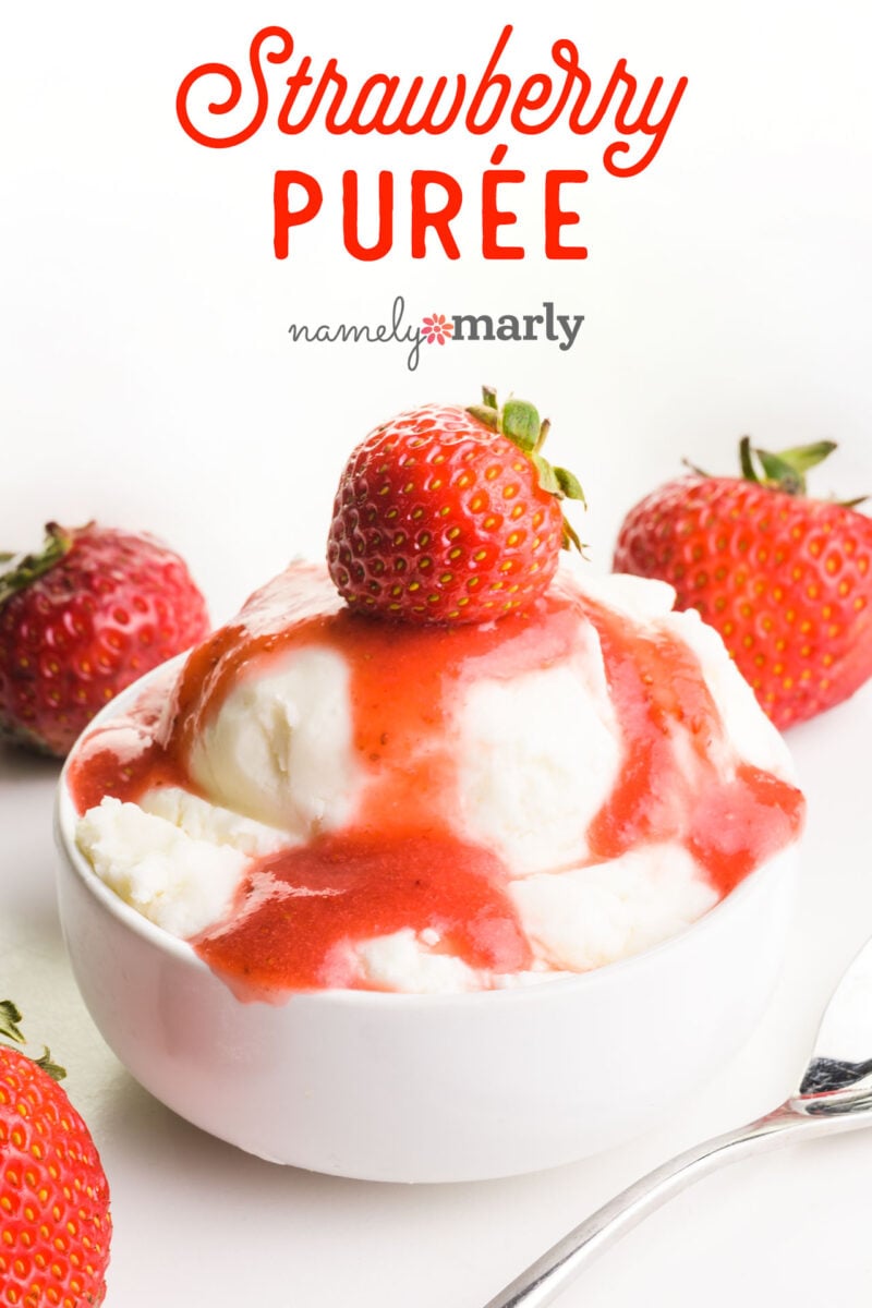 Bowl of vanilla ice cream topped with vibrant strawberry puree and fresh strawberries on a white background.