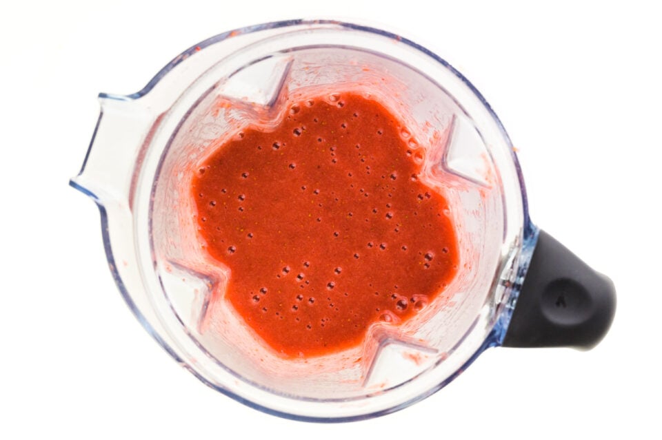 Looking down on a blender full of a red sauce.