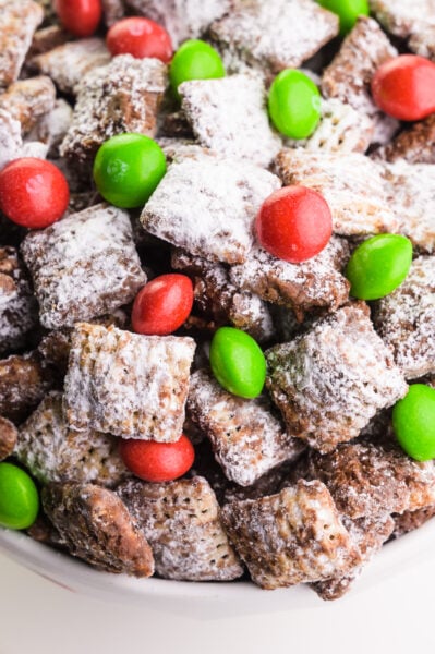 Looking down on a bow full of reindeer chow with red and green candies.