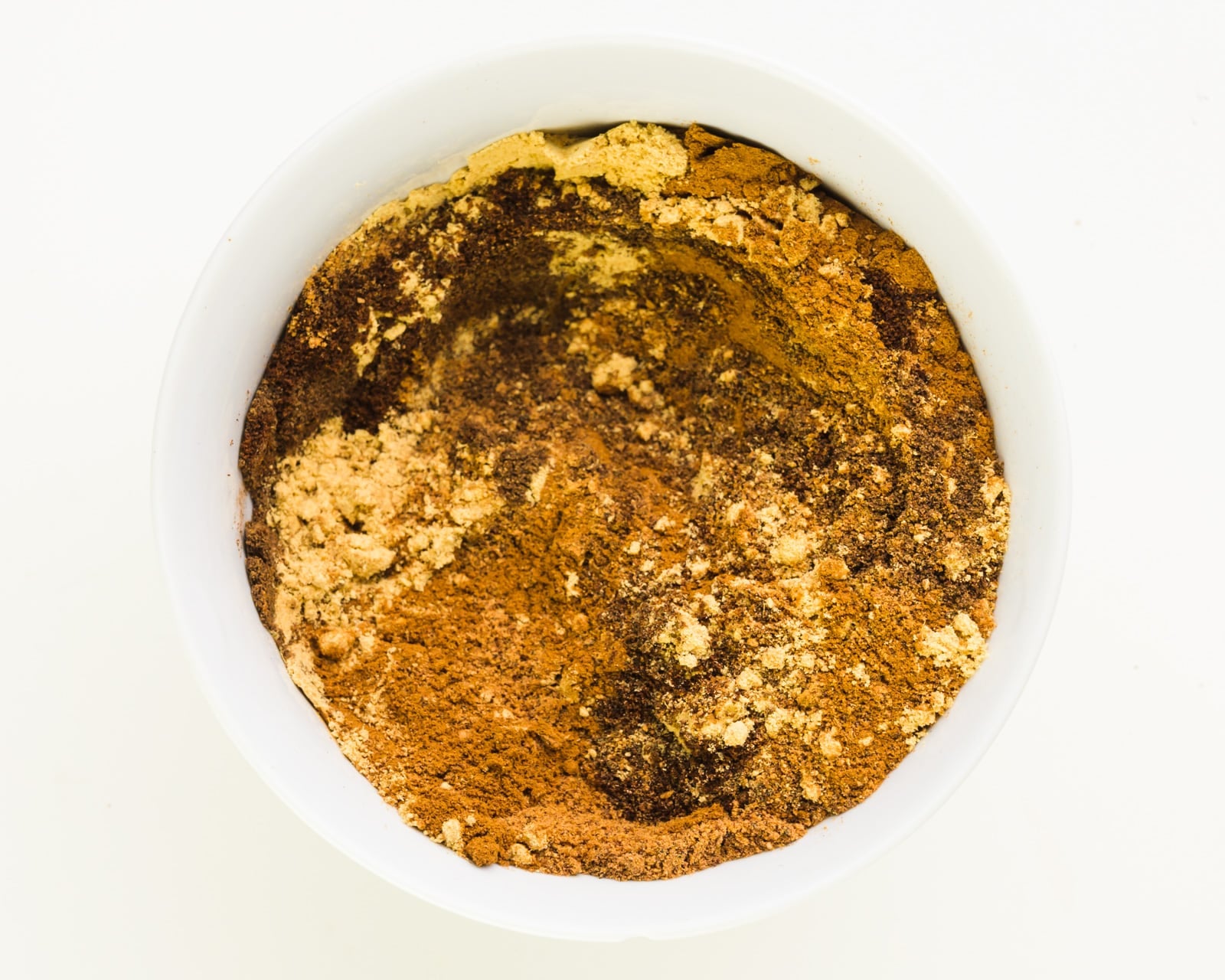 A bowl shows several spices swirled together.