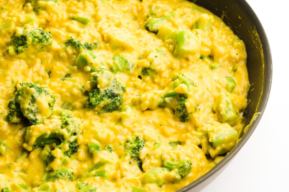 A skillet is full of vegan broccoli rice and cheese mixture.