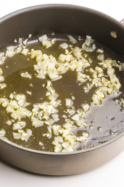 Onion is cooked until tender in a large pot.