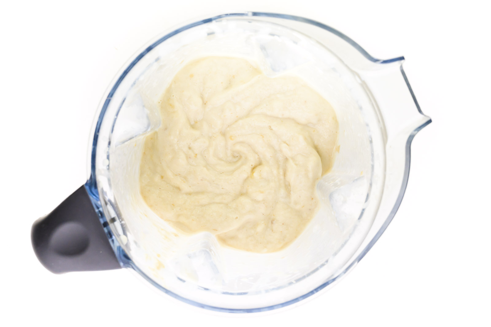Looking down on a blender full of a banana mixture.