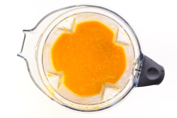 Looking down on a blender full of blended carrot soup.