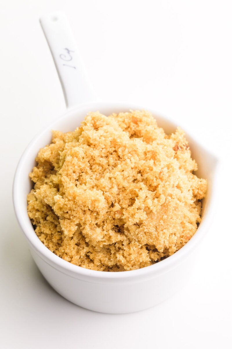 A white measuring cup holds homemade brown sugar.