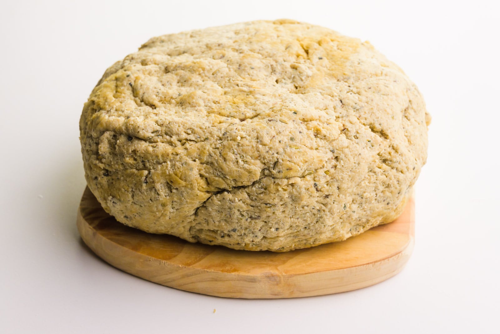 An oval loaf sits on a cutting board on a white counter.