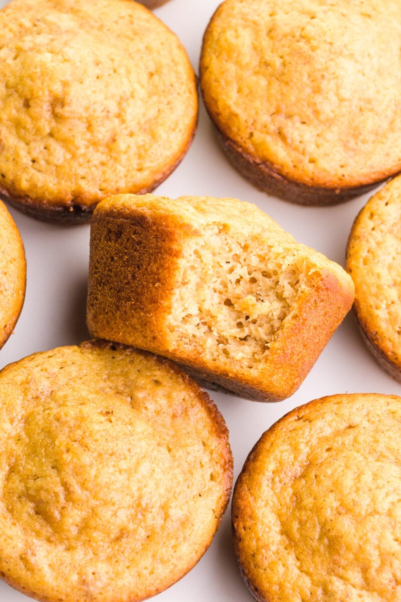 Looking down on a tray full of vegan bran muffins, one with a bite taken out.