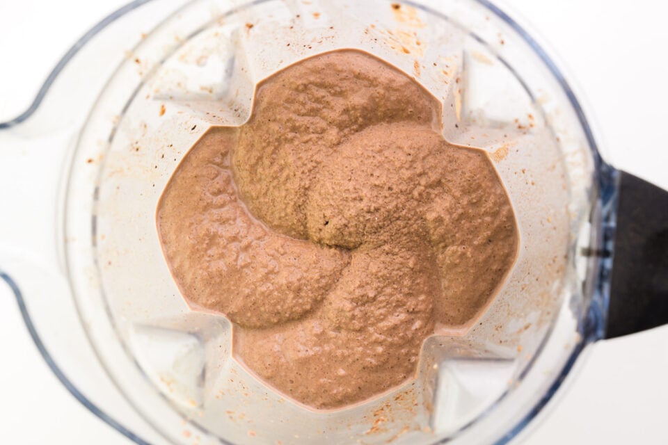 Looking down on a blender jar full of a frozen chocolate mixture.
