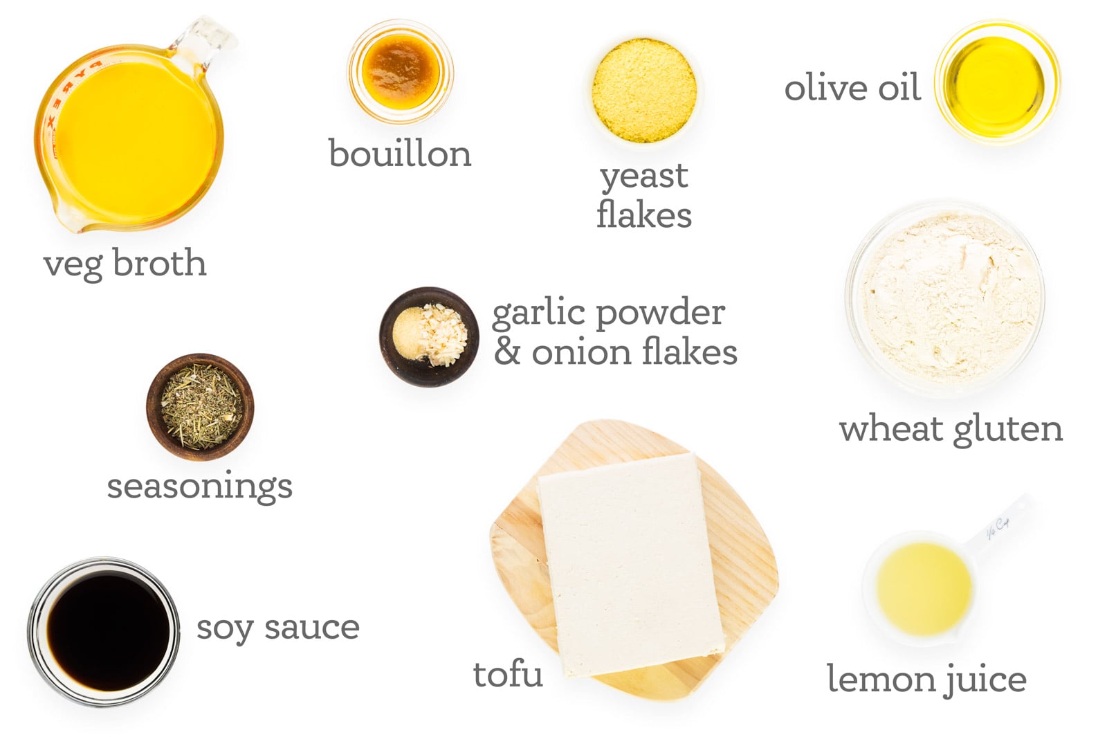 Ingredients are on a counter. The labels read, "veg broth, bouillon, yeast flakes, olive oil, wheat gluten, lemon juice, tofu, garlic powder & onion flakes, soy sauce, and seasonings."