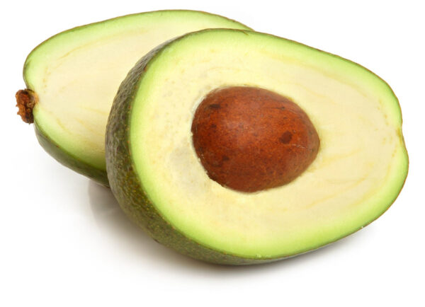 An avocado has been sliced in half, revealing the pit in side. The two halves are laying side-by-side.