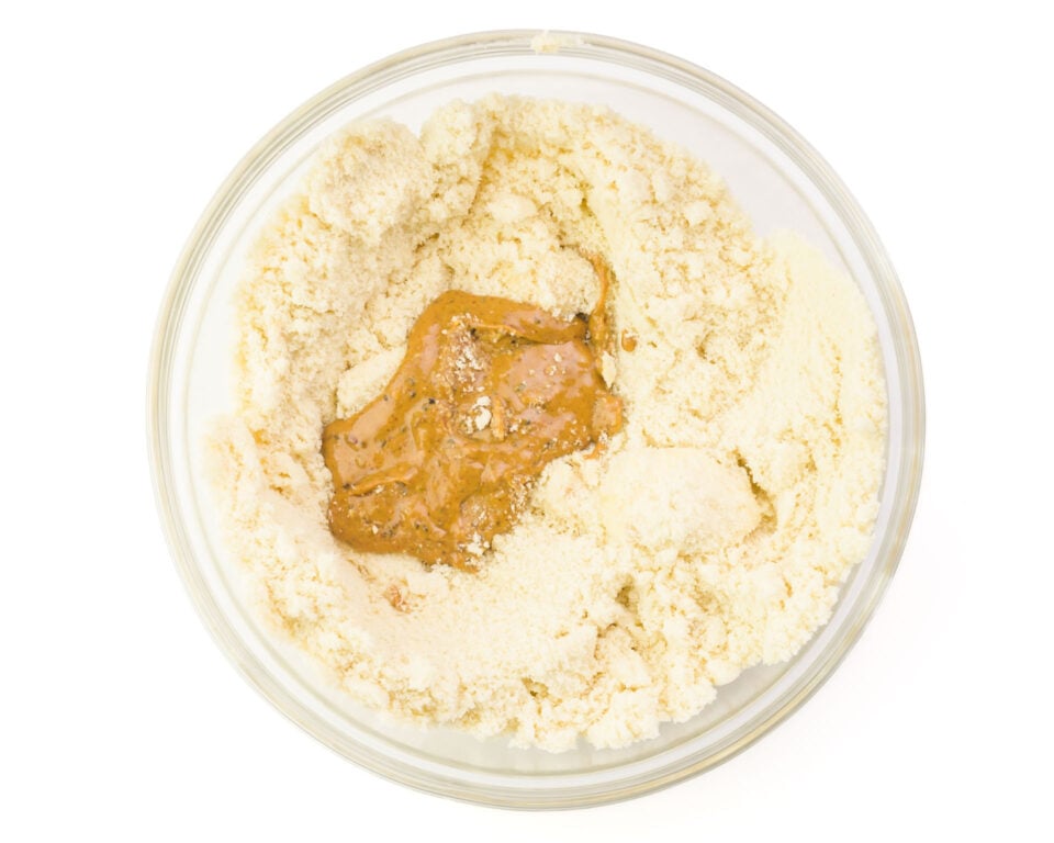 Looking down on a bowl with a flour mixture and almond butter in the middle.