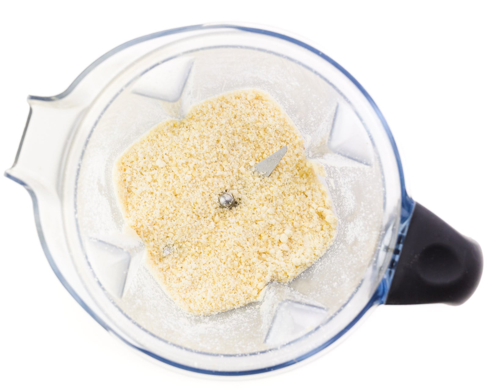 Looking down on a blender with almond flour in the bottom.