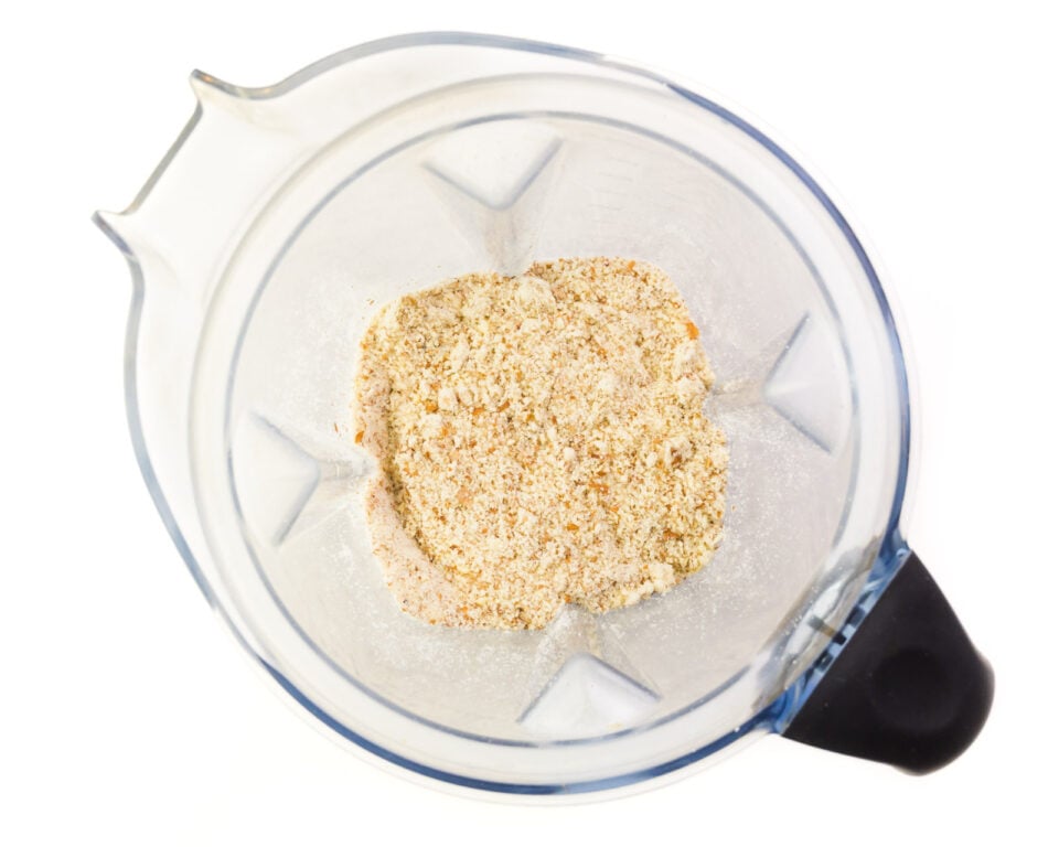Looking down on a blender with almond meal in the bottom.
