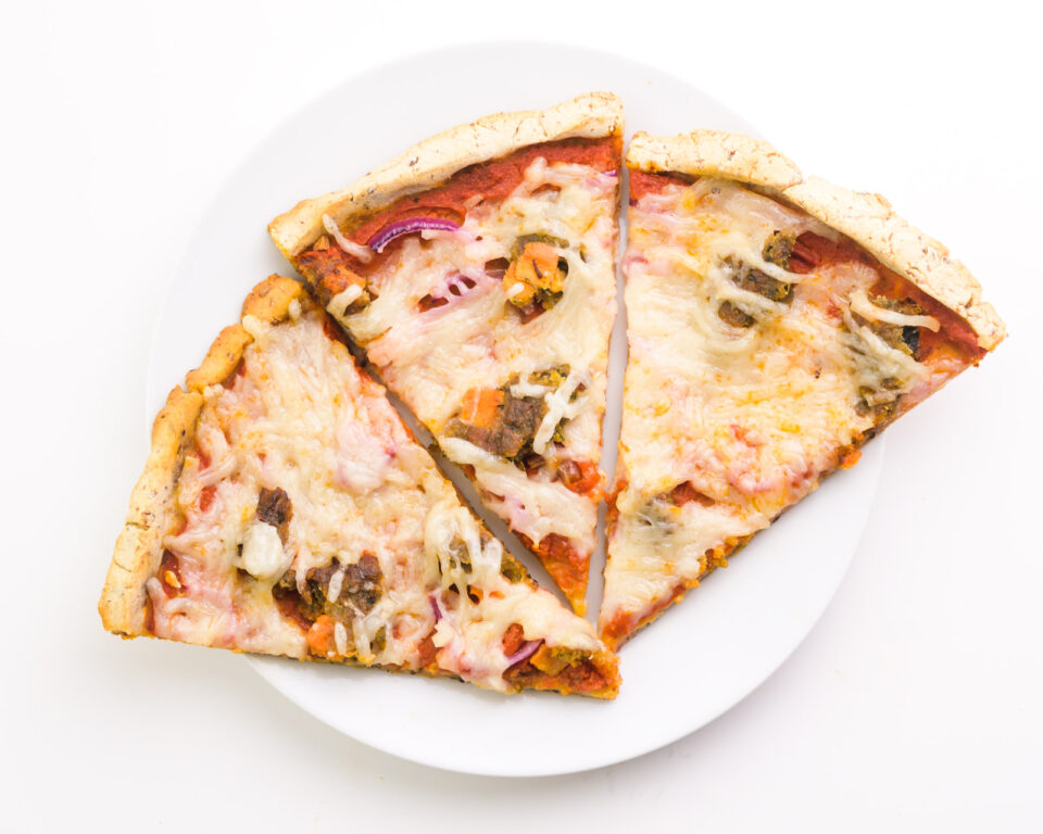 Looking down on a plate with three slices of pizza made with cassava flour.