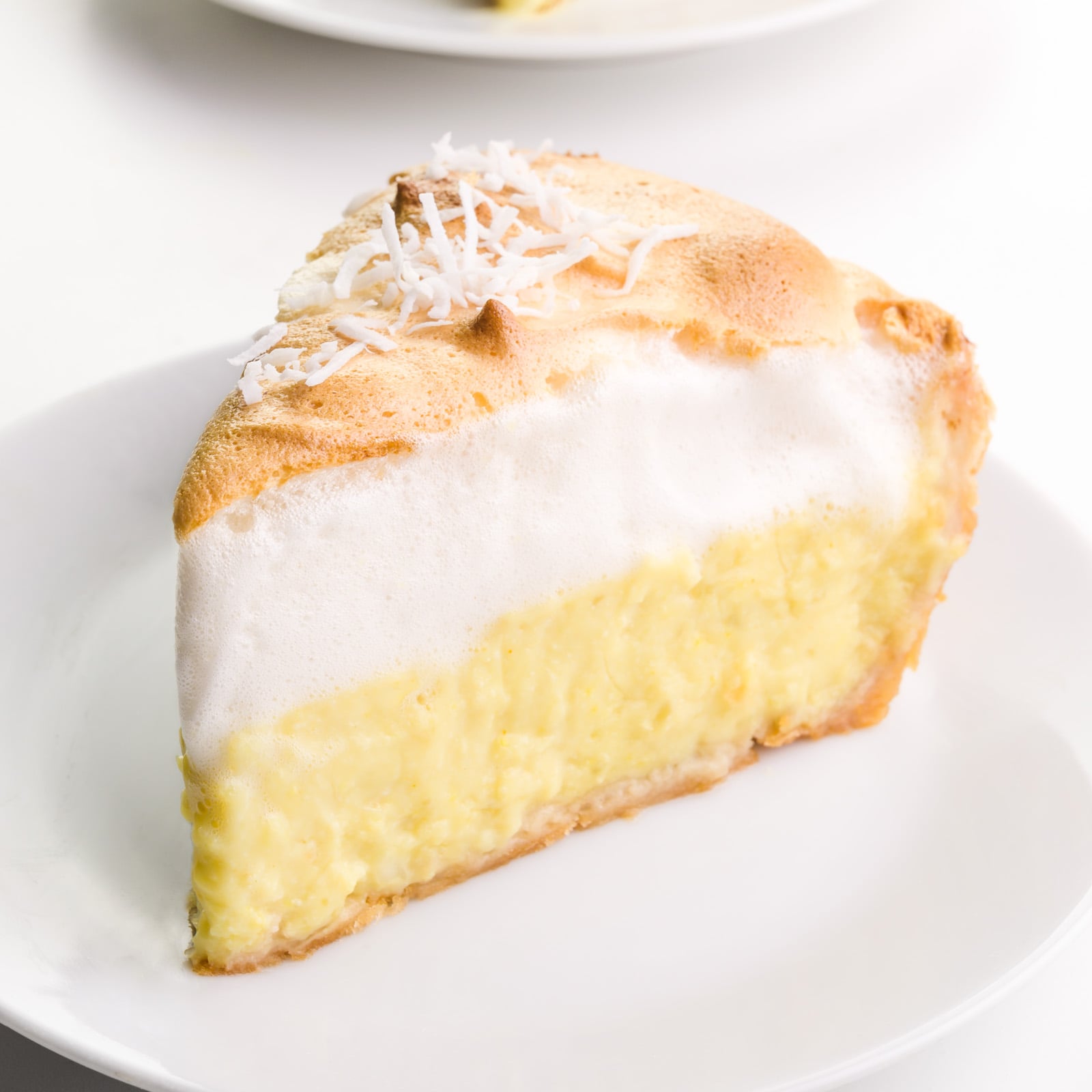 A slice of vegan coconut meringue pie sits on a plate.