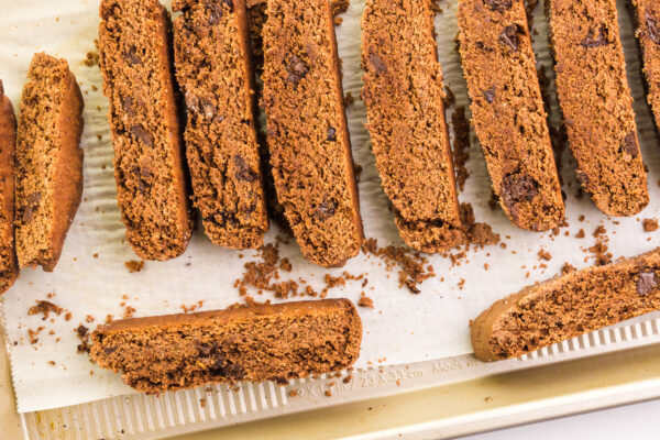 Biscotti have been sliced and are on a pan waiting for a second bake.
