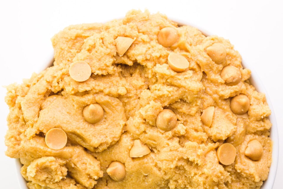 Looking down on a bowl full of cookie dough with peanut butter chips.