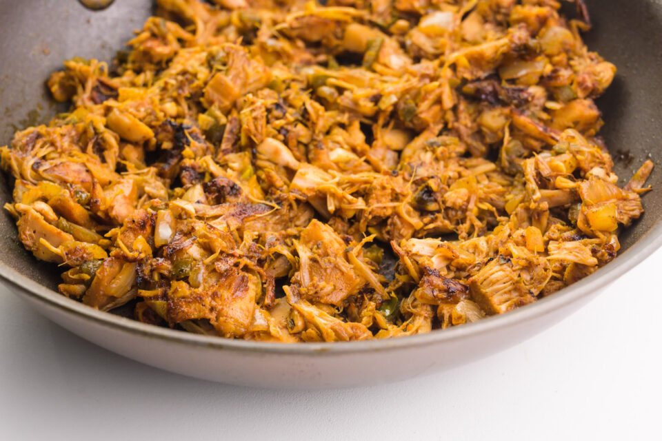 A skillet holds jackfruit being browned.