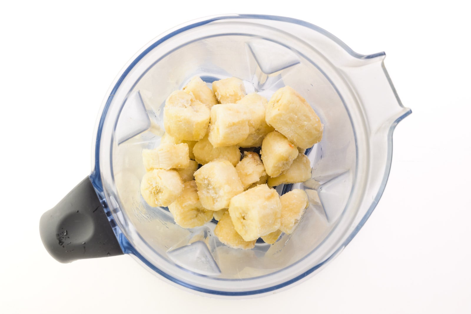 Frozen banana chunks are in the bottom of a bender jar.