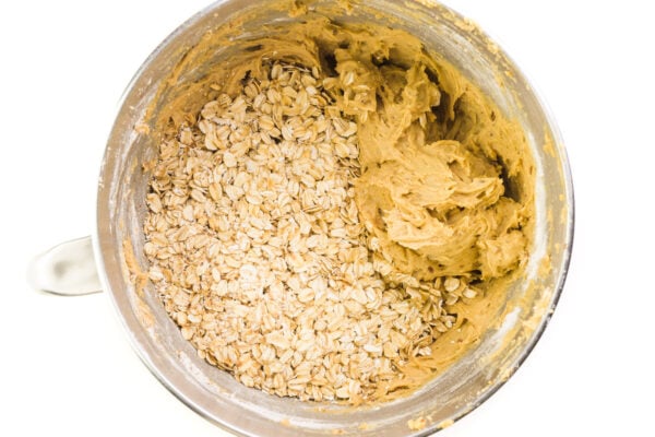 Looking down on a mixing bowl full of cookie dough batter and oats.