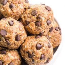 A bowl holds a mound of peanut butter energy bites with chocolate chips.