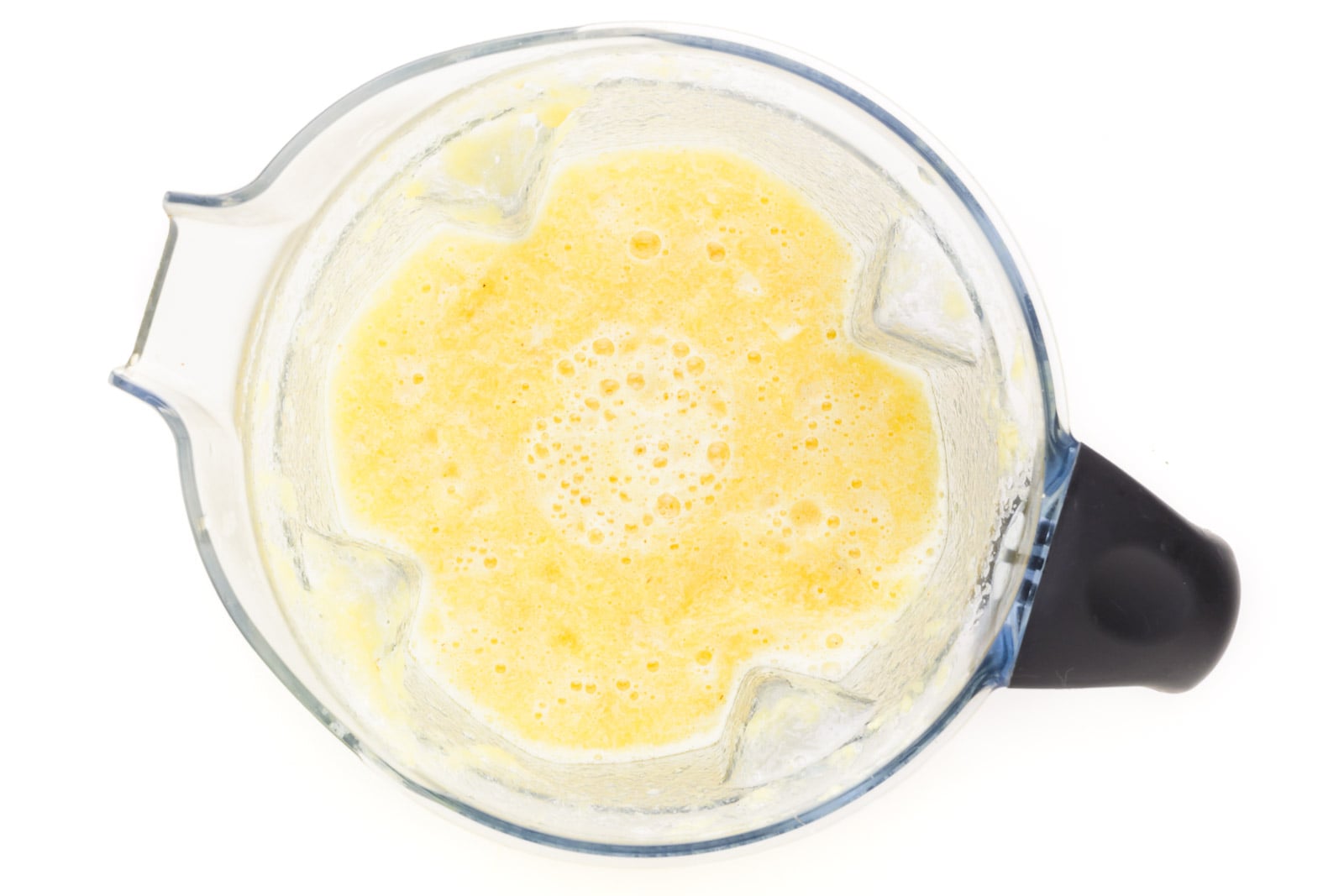 Looking down on pureed pineapples in a blender.