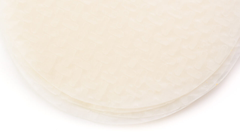 Looking down on a stack of rice papers on a white counter.