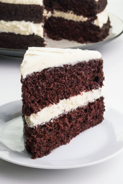 A slice of Suzy Q Cake sits on a plate in front of the rest of the cake.