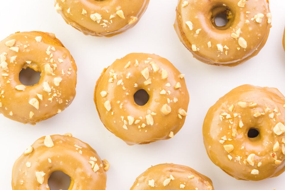 Looking down on a counter full of vegan caramel donuts.