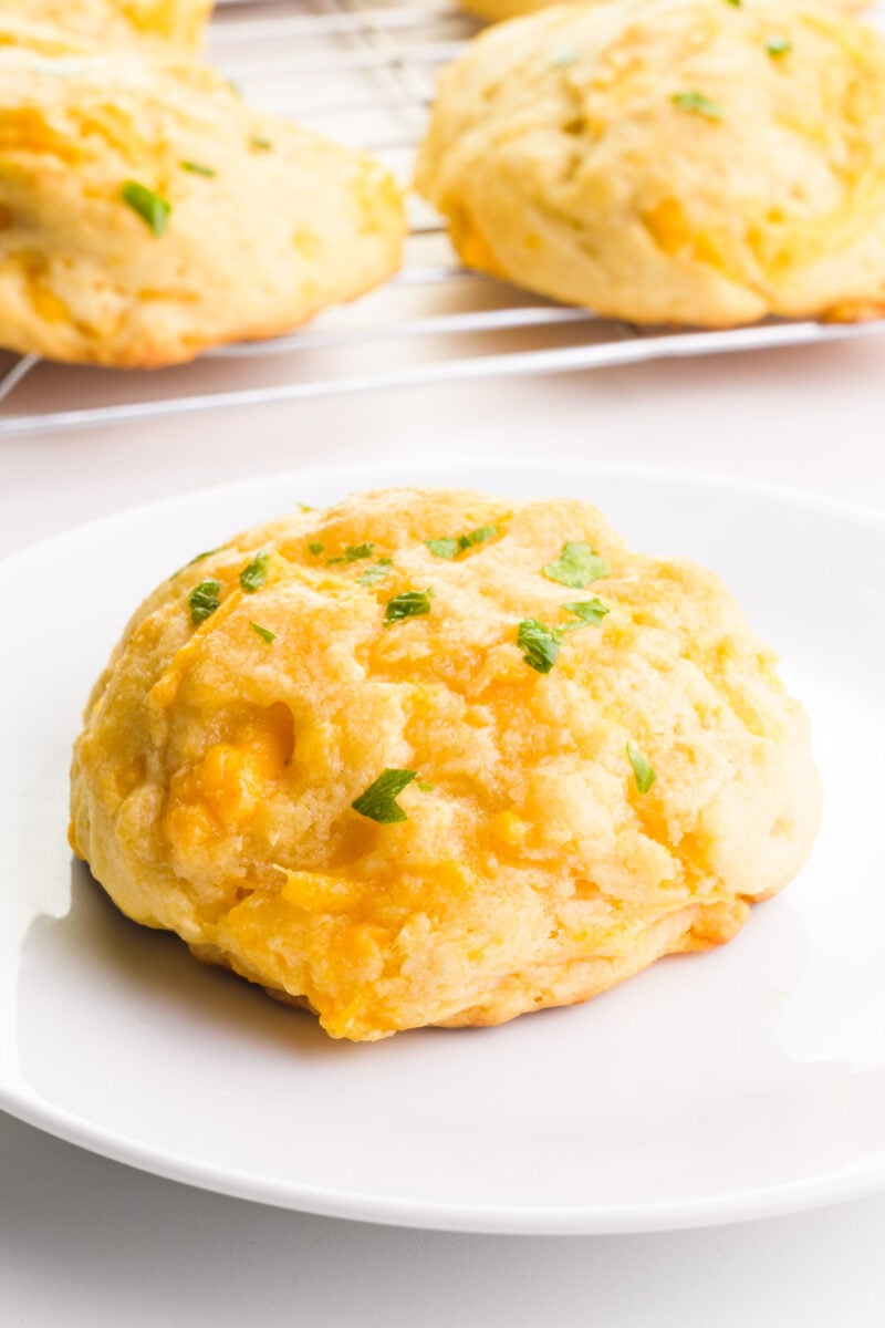 Vegan cheddar bay biscuits sit on a white background.  