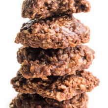 A stack of vegan no-bake cookies shows the top one with a bite taken out.